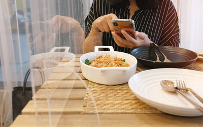 Midsection of man using laptop on table