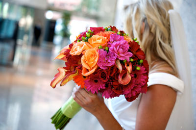 Midsection of woman holding rose bouquet