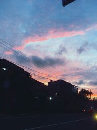 Silhouette buildings against sky at sunset