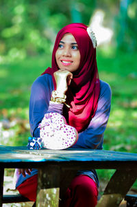 Portrait of young woman sitting on table