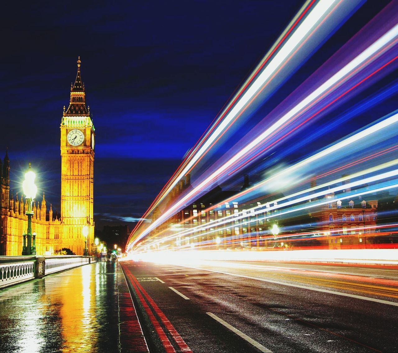 illuminated, architecture, long exposure, built structure, transportation, city, light trail, building exterior, motion, speed, night, blurred motion, road, sky, travel destinations, travel, city life, capital cities, car, water