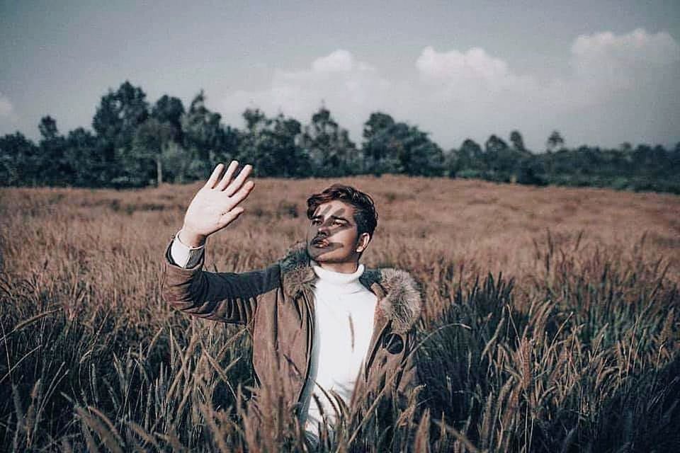 one person, field, plant, standing, young adult, nature, adult, landscape, land, grass, sky, tree, front view, emotion, portrait, human body part, happiness, day, outdoors, human arm, hand, arms raised