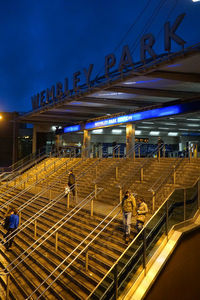 High angle view of people walking on illuminated bridge at night