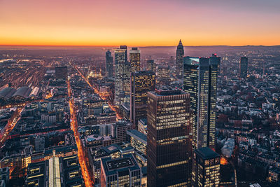 Aerial view of buildings in city during sunset