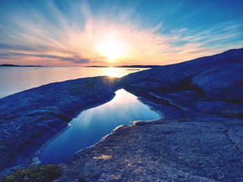 Rich reflection in water pool. sun close to sea or ocean level, romantic and dramatic light.