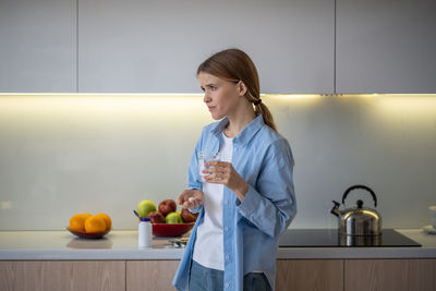 Portrait of female doctor holding stethoscope at home