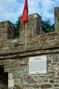 Low angle view of text on wall against building