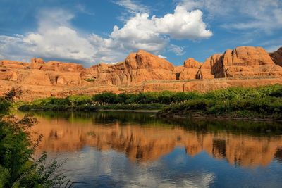 Scenic view of rock formations on landscape against cloudy sky