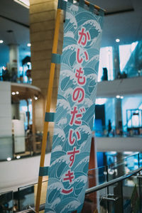 Low angle view of text hanging on pole in city