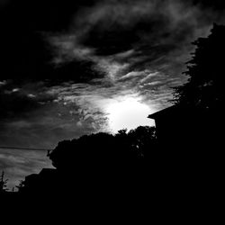 Low angle view of silhouette tree against cloudy sky