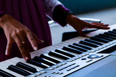 Cropped image of woman playing piano