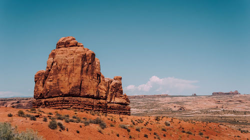 Scenic view of rock formations and landscape against blue sky