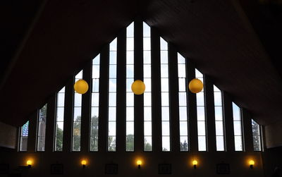 Low angle view of illuminated lights hanging on ceiling of building