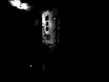 Silhouette people standing in illuminated dark room
