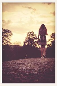 Silhouette of woman against sky at sunset