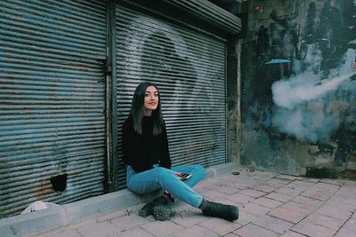 Portrait of young woman sitting outdoors