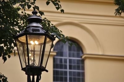 Low angle view of illuminated street light against building