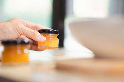 Cropped hand of woman using mobile phone on table