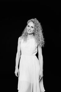 Portrait of a smiling young woman against black background