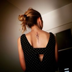 Rear view of woman standing against wall