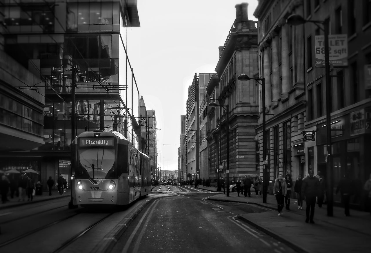 ROAD AMIDST CITY AGAINST SKY