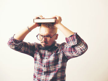 Portrait of young man standing against white background