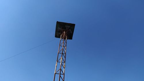 Low angle view of communications tower against clear blue sky