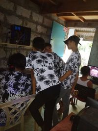 Rear view of people standing against wall