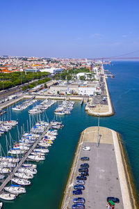 High angle view of cityscape and sea against blue sky