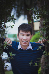 Portrait of smiling boy standing against plants