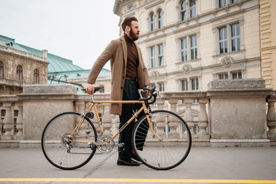 Side view of man with bicycle at street