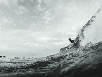 Man surfing in sea against sky