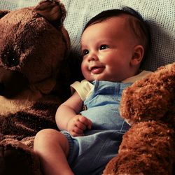 Baby boy with stuffed toys relaxing at home