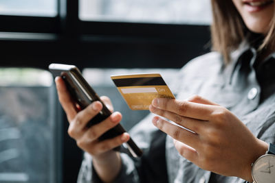 Midsection of woman shopping through credit card