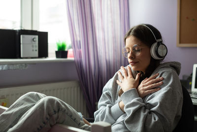 A girl delighted with new songs. listens to music on wireless headphones.