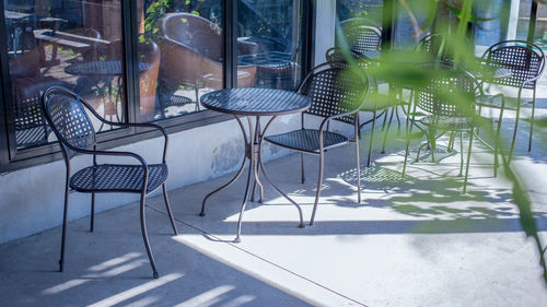 Empty chairs and tables at sidewalk cafe