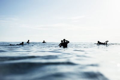 People enjoying in sea against sky