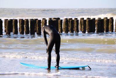 Man with surfboard standing on beach