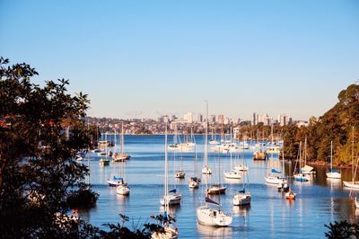 Boats sailing in river against clear sky