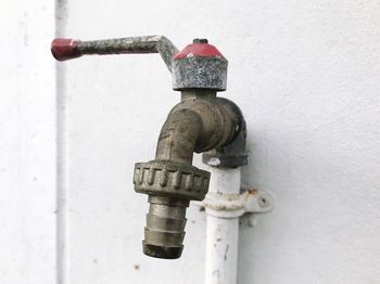 Close-up of faucet against white wall