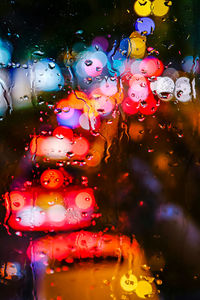 Close-up of illuminated lighting equipment on wet glass