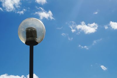 Low angle view of street light against blue sky