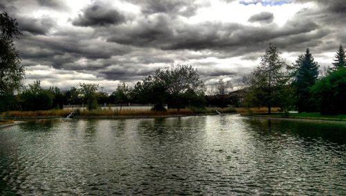 Scenic view of calm lake against cloudy sky