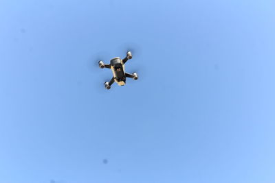 Low angle view of airplane against clear blue sky