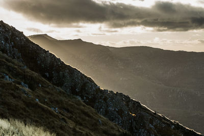 Scenic view of mountains against cloudy sky