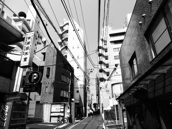 Cables amidst buildings over road in city