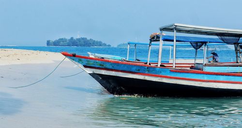 Fishing boats moored on sea against sky