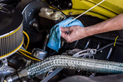 Cropped hand of man repairing car engine