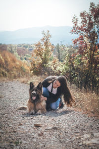 Full length of woman with dog against trees