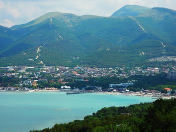 Aerial view of townscape by mountains against sky